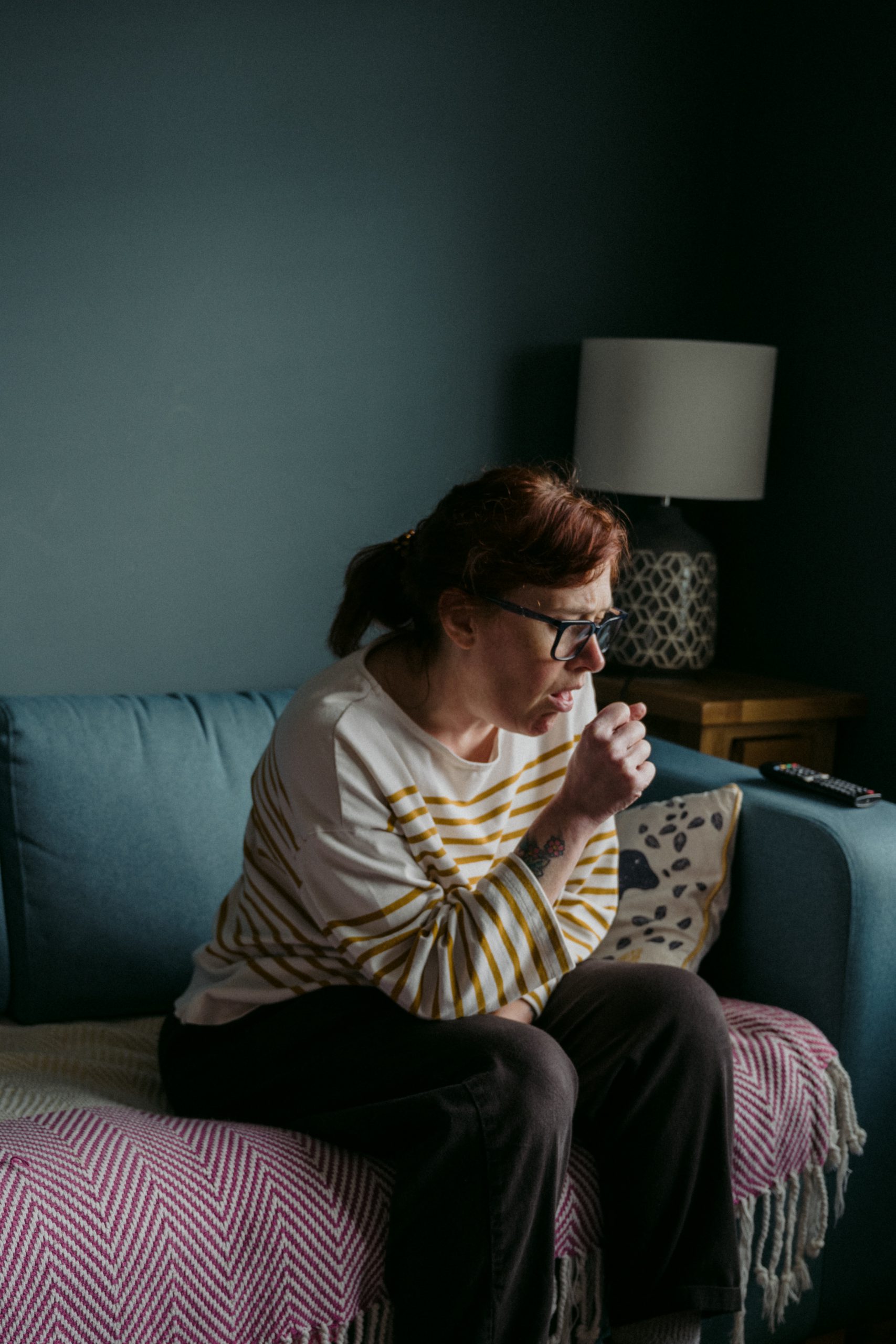 woman in white crew neck t-shirt sitting on gray sofa