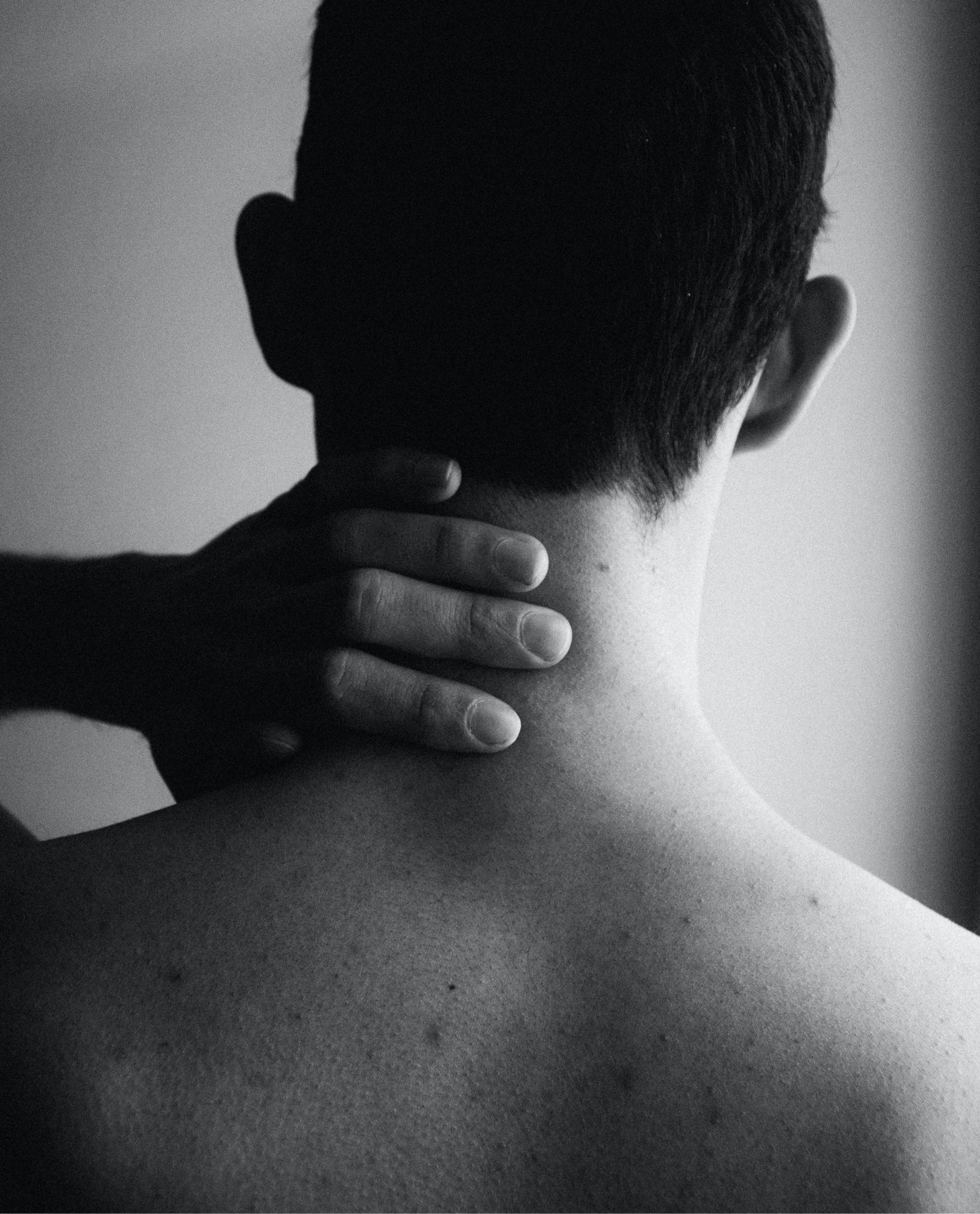 grayscale photo of man holding his head