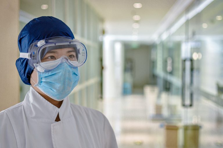 man in white dress shirt wearing blue face mask