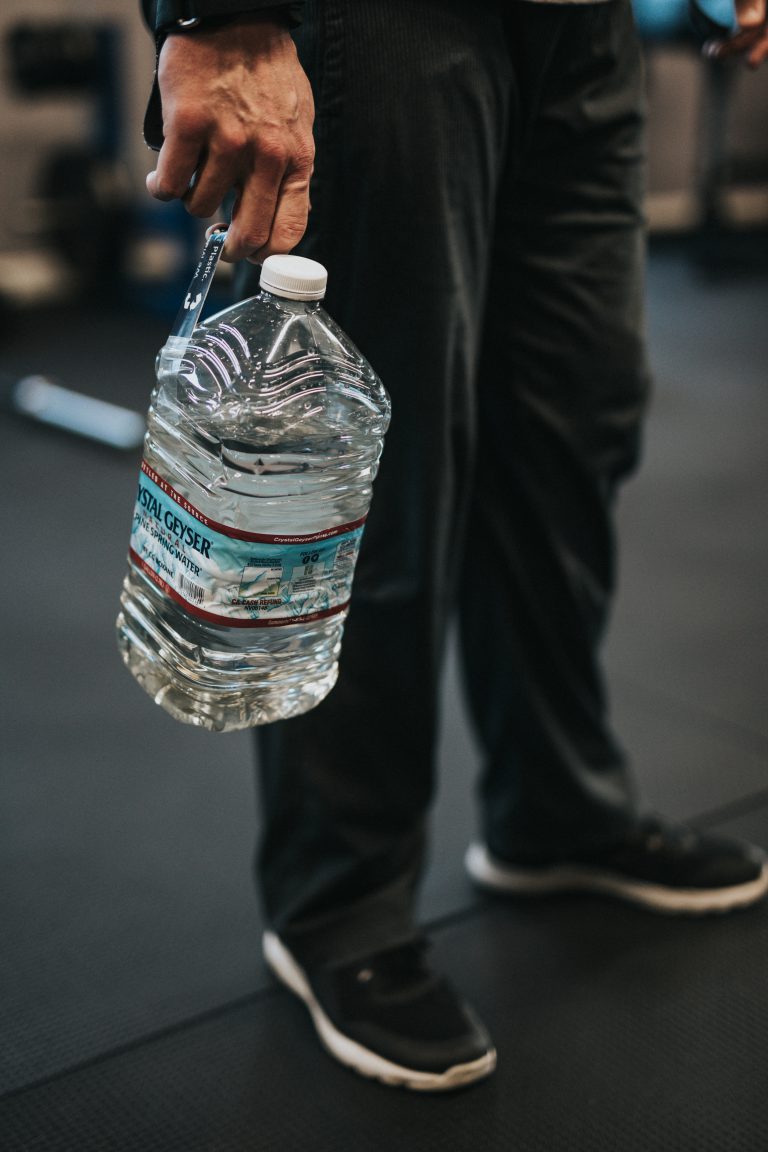 person holding clear plastic bottle