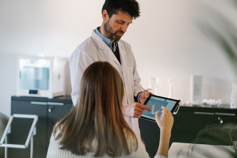 man in white dress shirt holding black tablet computer