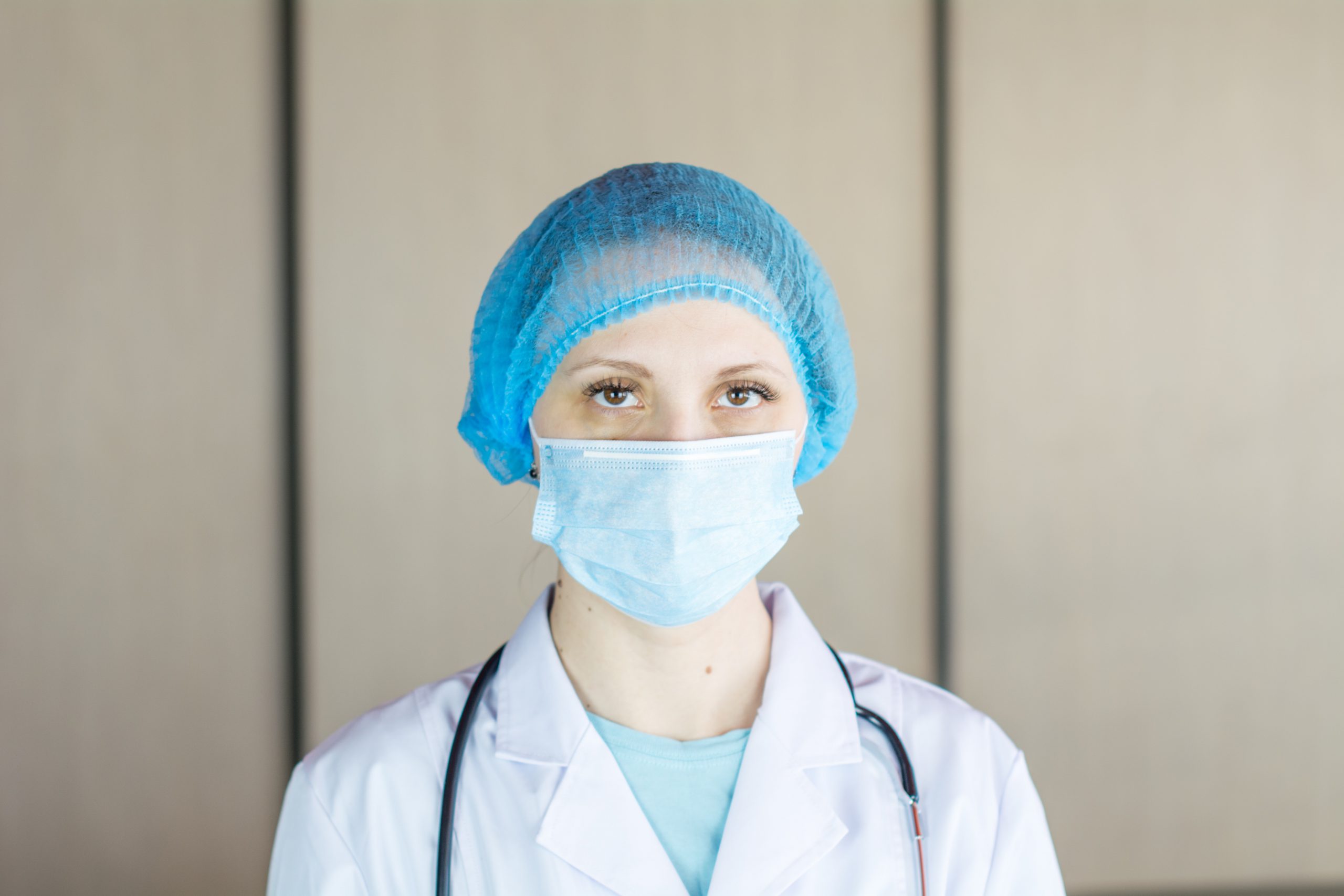 person wearing blue knit cap and white face mask